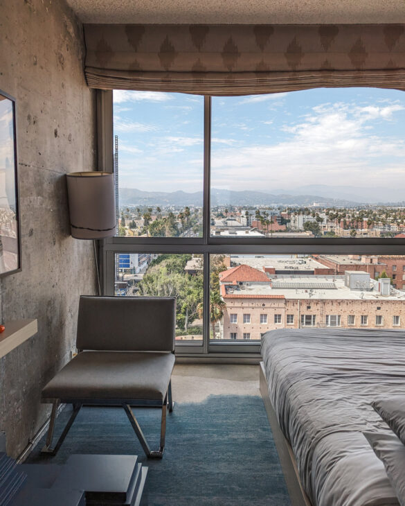 A comfortable chair placed near a large glass window provides a stunning city view.