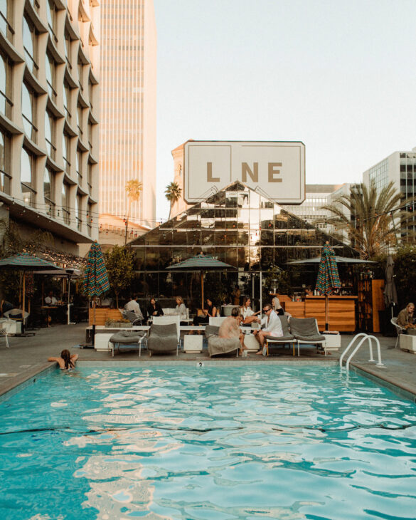 A group of individuals relaxing near the pool area of The Line Hotel.