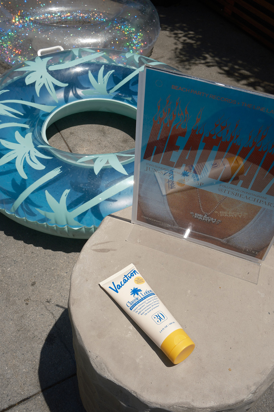 Sunscreen lotion is on the table, and swimming rings are positioned close by.