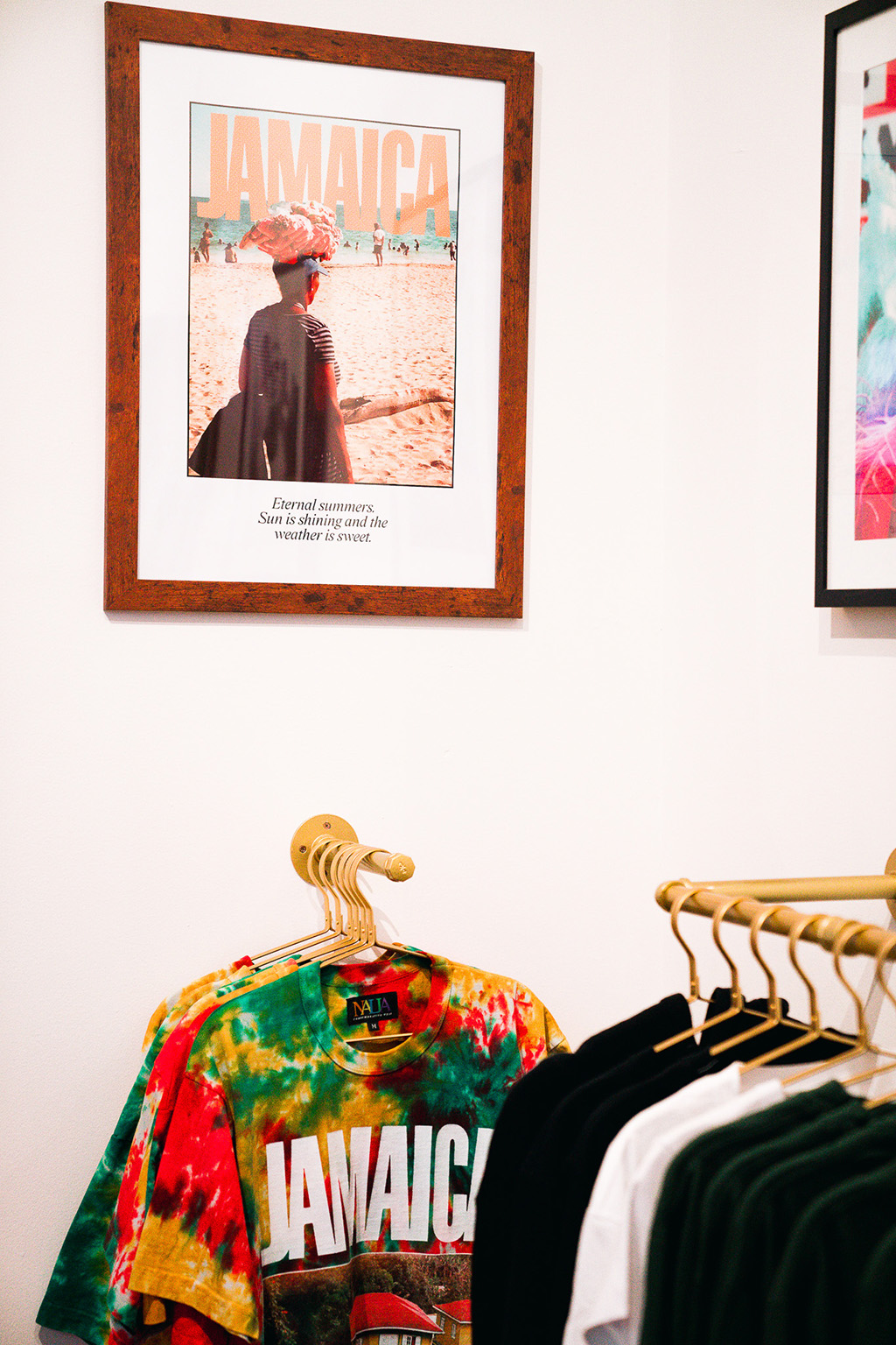 a Jamaica poster on the wall and Jamaica sweatshirts on the clothing rack