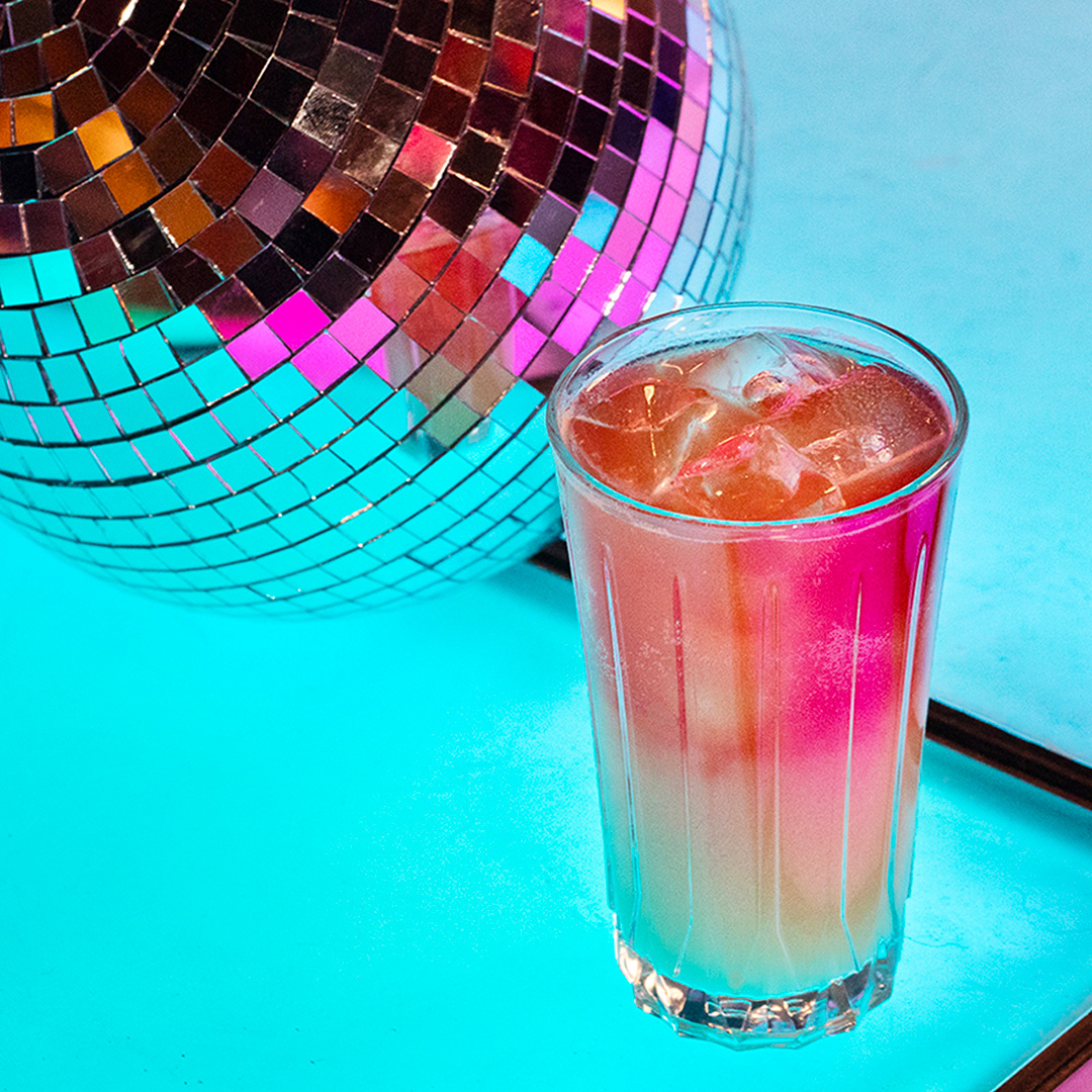 a glass of cocktail and disco ball