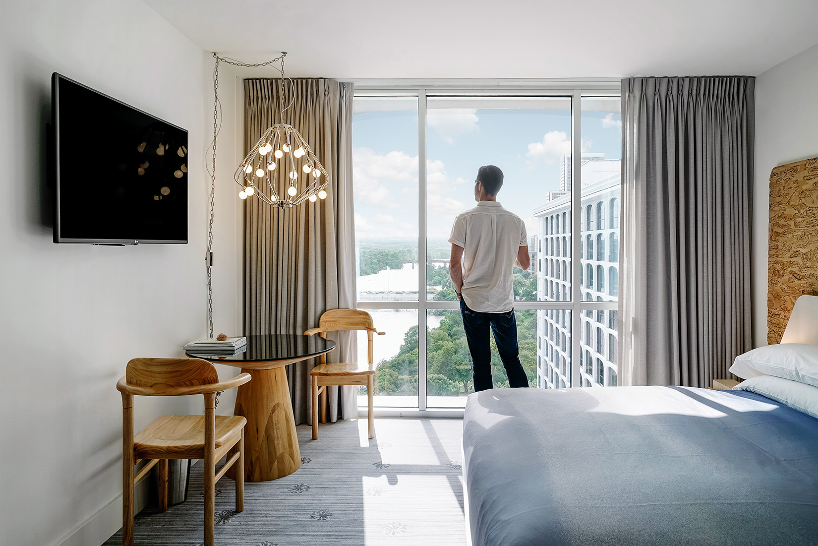 A man watching a river view from the window