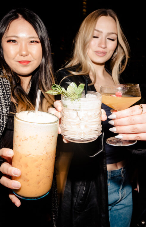 Women hold beautiful-looking cocktails in different types of glasses