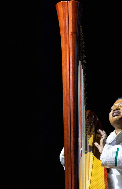 A portrait of Destiny Muhammad playing a harp